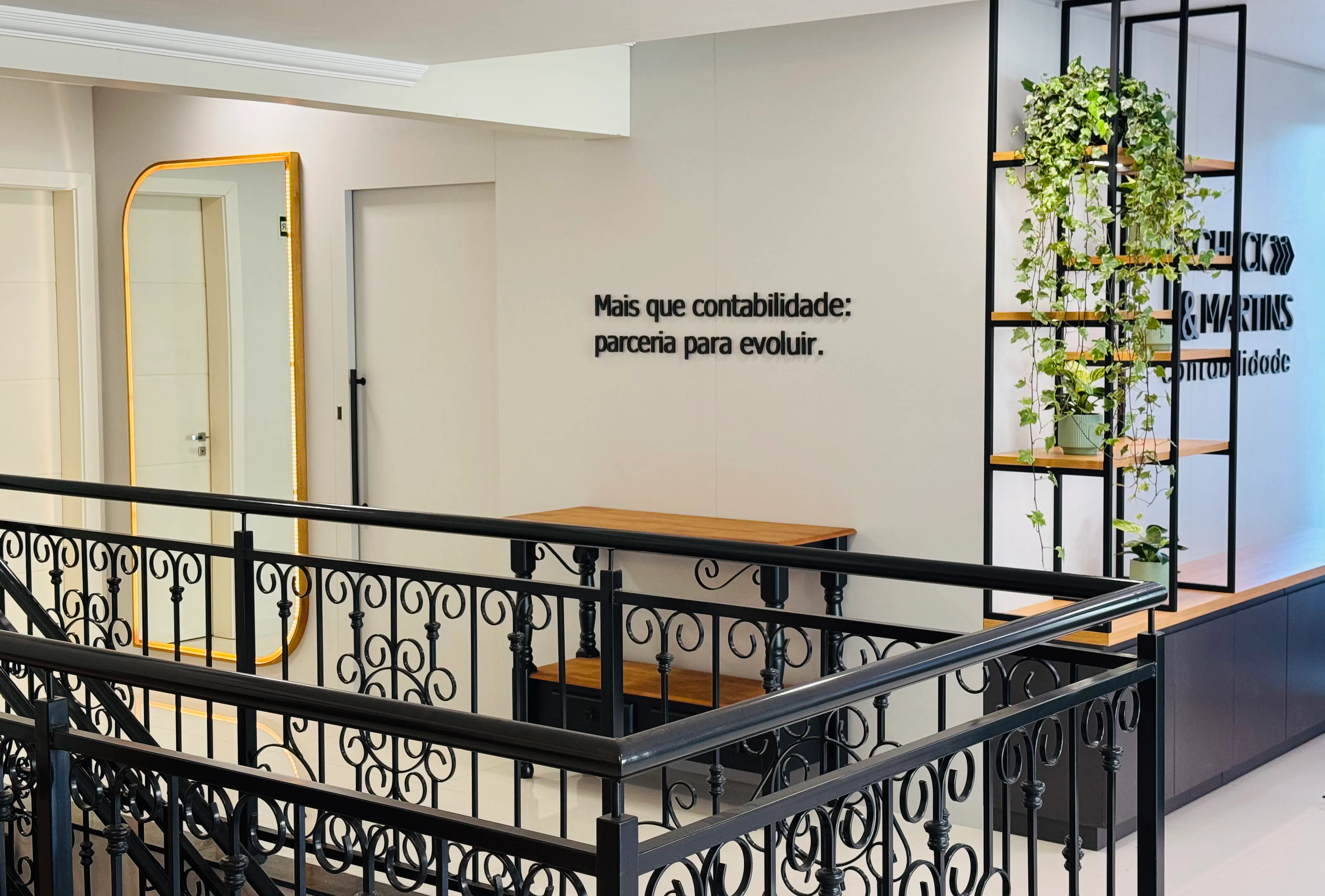 Mezanino do escritório com a frase "Mais que contabilidade: parceria para evoluir" na parede